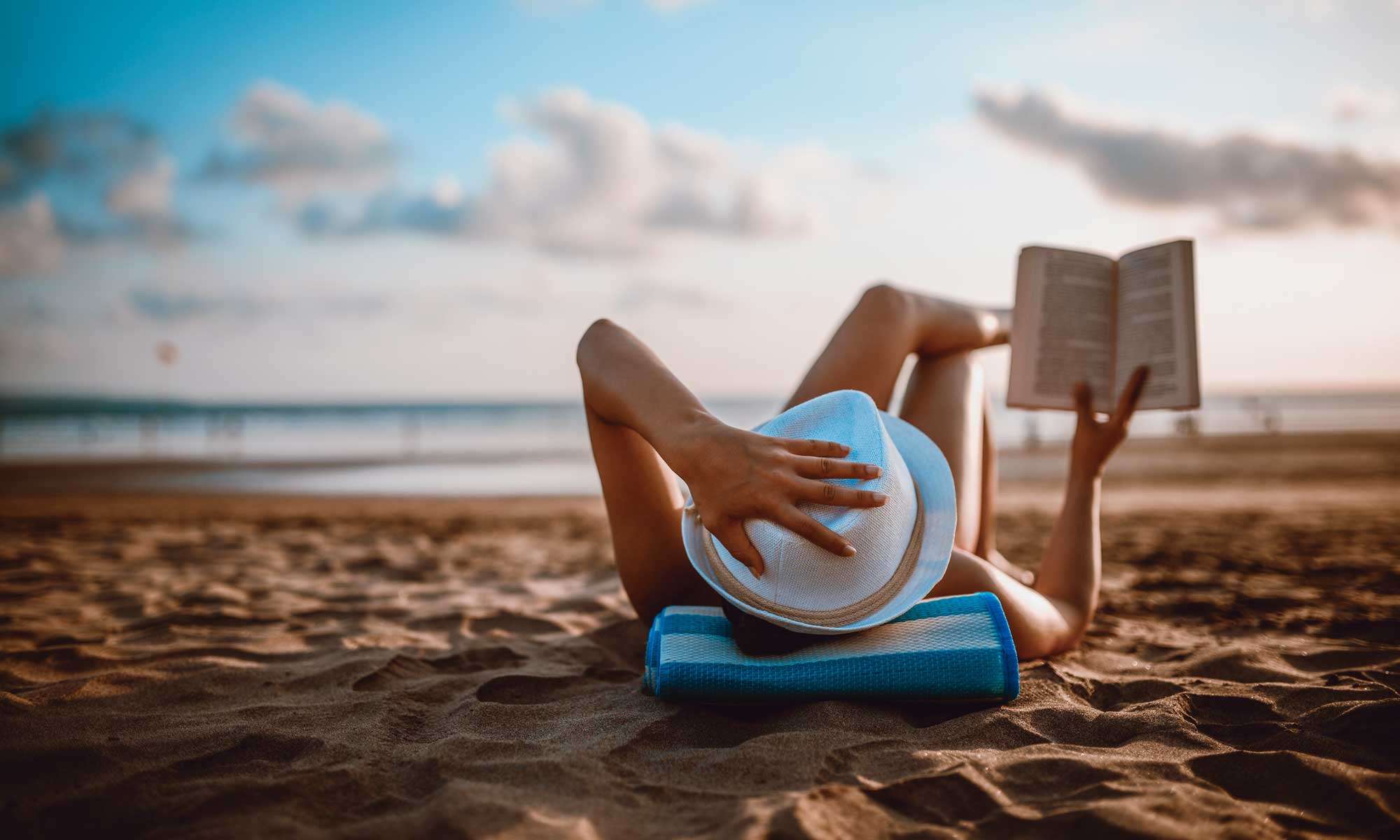 Woman is reading a book on the beach